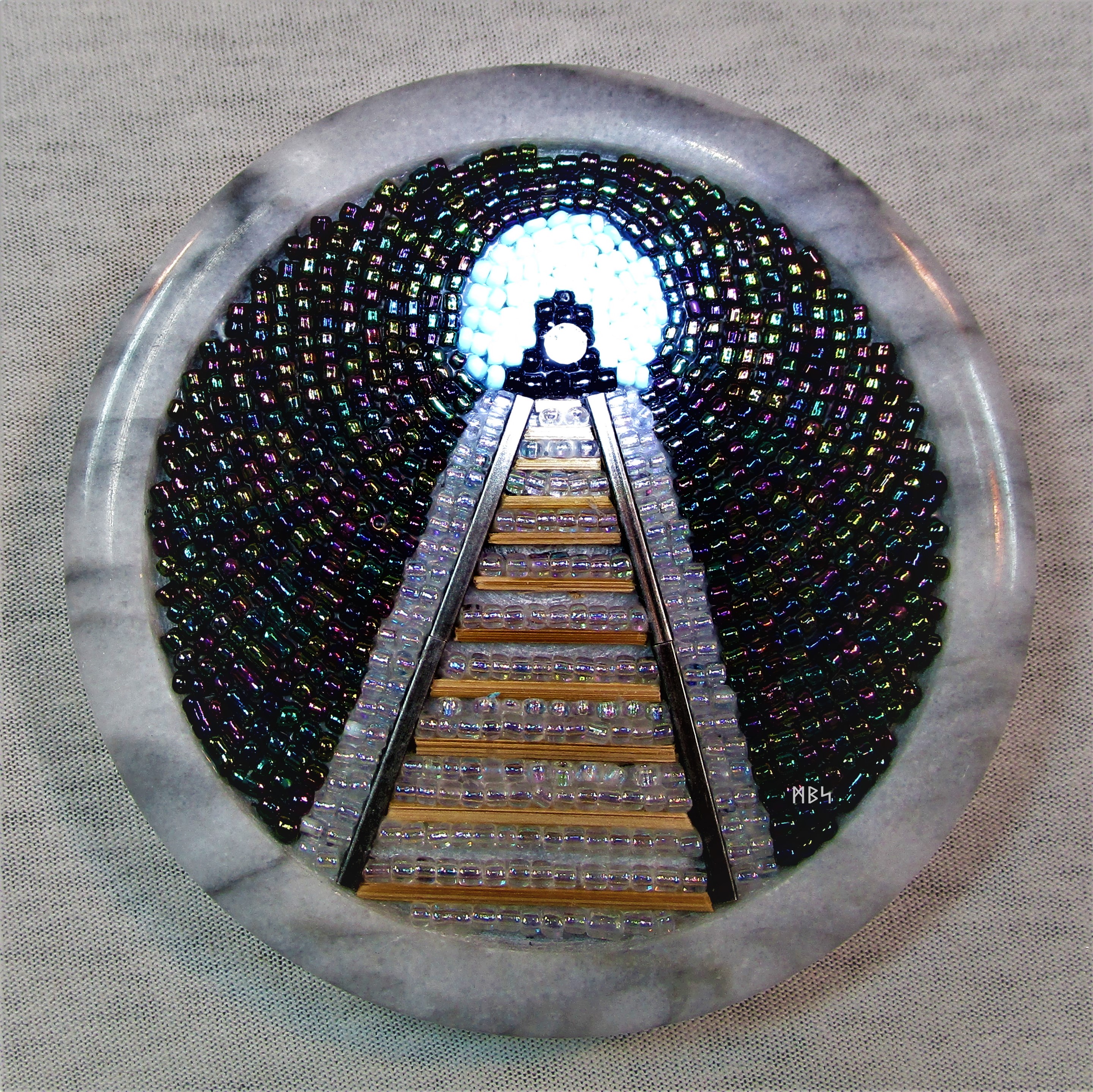 "Train Entering a Tunnel Inside a Coaster," a bead mosaic by Mike Smetzer.